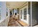 Inviting covered front porch featuring rocking chairs and double french doors at 1898 Woodland Hills Nw Ave, Atlanta, GA 30318