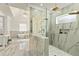 Elegant bathroom showcasing a marble-tiled shower, a soaking tub, vanity table, and a stylish chandelier at 2634 Greenes Ln, Powder Springs, GA 30127