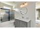 Bathroom vanity with grey cabinets, stone countertop, and a glass enclosed shower and tub at 2634 Greenes Ln, Powder Springs, GA 30127