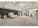 Spacious main bedroom featuring tray ceilings, dark accent wall, chandelier and neutral carpet at 2634 Greenes Ln, Powder Springs, GA 30127