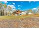 View of open pavilion with dark roof amongst treeline and grassy backyard at 2634 Greenes Ln, Powder Springs, GA 30127