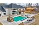 Aerial view of pool with waterfall and patio area with modern lounge chairs and fire pit at 2634 Greenes Ln, Powder Springs, GA 30127