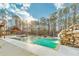 Backyard pool and waterfall feature framed by mature trees and a cozy cabana at 2634 Greenes Ln, Powder Springs, GA 30127