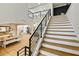 Open-concept staircase featuring wooden steps, white risers, black metal railings, and natural light at 2634 Greenes Ln, Powder Springs, GA 30127