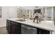 Close-up of the kitchen island featuring a stainless-steel sink, white countertops, and view of the open-concept living area at 2720 Ravencliff Dr, Austell, GA 30168