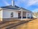 Back of house with a stone foundation and covered porch with white pillars at 3393 Milan Ct, Douglasville, GA 30135