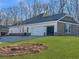 Side view of home featuring a two car garage and landscaped front yard at 3393 Milan Ct, Douglasville, GA 30135