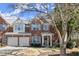 Charming brick townhome featuring a two-car garage and manicured front yard at 913 Thornington Pl, Roswell, GA 30075