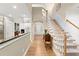 Hallway with hardwood floors leads to kitchen and staircase, with view into other rooms at 913 Thornington Pl, Roswell, GA 30075