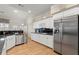 Well-lit kitchen with stainless steel appliances, granite countertops, and ample cabinet space at 913 Thornington Pl, Roswell, GA 30075