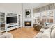 Cozy living room with fireplace, built-in shelving, hardwood floors and ample seating at 913 Thornington Pl, Roswell, GA 30075