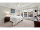 Bright main bedroom featuring tray ceilings, plush carpet, and natural light from a large window at 913 Thornington Pl, Roswell, GA 30075