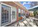 Rear brick patio featuring an outdoor table, chairs, grill, and sun umbrella at 913 Thornington Pl, Roswell, GA 30075