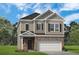 Charming two-story home features a brick facade, gray siding, and a two-car garage at 1265 Elowen Dr, Austell, GA 30168