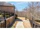 Multi-level backyard with stone retaining wall, iron fencing, mature trees, and stone walkway at 15 York Trce, Cartersville, GA 30121