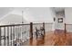 Hallway loft with hardwood floors, wrought iron railing, and distant view of the living room at 15 York Trce, Cartersville, GA 30121