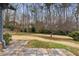 Stone patio and sloped backyard featuring tall trees and grass at 2533 Schooner Cv, Snellville, GA 30078