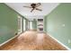 Bright bedroom with hardwood floors, ceiling fan, and fresh green paint at 2533 Schooner Cv, Snellville, GA 30078