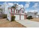 Side view of charming two-story brick home with a two-car garage and manicured yard at 324 Cheri Pl, Jonesboro, GA 30238