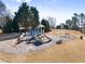 Community playground with slides, swings, and climbing structures, set in a grassy area with mature trees at 4445 Trilogy Park Trl, Hoschton, GA 30548