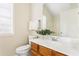 Bright bathroom with a wood vanity, white countertop, and decorative plant at 4519 Legend Hollow Ln, Powder Springs, GA 30127