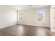 Cozy bedroom with wood-look flooring, neutral paint, and natural light from two windows at 4519 Legend Hollow Ln, Powder Springs, GA 30127