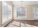 Bright dining area featuring large windows, modern chandelier, and wood-look flooring at 4519 Legend Hollow Ln, Powder Springs, GA 30127