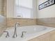 Relaxing bathtub featuring chrome fixtures and surrounding ceramic tiles, offering a peaceful retreat at 500 Anfield Dr, Woodstock, GA 30188