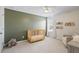 Bedroom room with a green accent wall, crib, chair, and wall-mounted bookshelves at 500 Anfield Dr, Woodstock, GA 30188