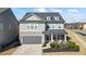 Charming two-story home with stone accents, a gray garage door, and manicured landscaping at 500 Anfield Dr, Woodstock, GA 30188