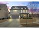 Charming two-story home with stone accents, a gray garage door, and manicured landscaping at dusk at 500 Anfield Dr, Woodstock, GA 30188