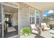 Inviting front porch with chairs, stone accents, and a view into the home's foyer and living spaces at 500 Anfield Dr, Woodstock, GA 30188