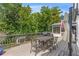 Outdoor back deck is perfect for entertaining, with a dining table and grill surrounded by lush trees at 7010 Hunters Knl, Atlanta, GA 30328