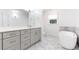 This light-filled bathroom is designed with a modern soaking tub, gray vanity, and sleek white tile at 7010 Hunters Knl, Atlanta, GA 30328