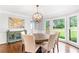 Bright dining room with hardwood floors, a modern chandelier, and large windows overlooking the yard at 7010 Hunters Knl, Atlanta, GA 30328