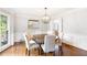 Dining room featuring hardwood floors, wainscoting, modern chandelier and view into breakfast nook at 7010 Hunters Knl, Atlanta, GA 30328