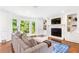 Cozy living room with fireplace, built-in bookshelves, hardwood floors, and natural light from large windows at 7010 Hunters Knl, Atlanta, GA 30328