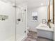 Clean bathroom with a glass shower, white subway tiles, a sleek vanity, and a window for natural light at 5065 Sunrise Ln, Cumming, GA 30041
