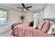 Inviting bedroom featuring warm tones, natural light, a ceiling fan, and a comfortable bed with stylish pillows at 5065 Sunrise Ln, Cumming, GA 30041