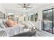 Bright main bedroom featuring two windows, sliding glass doors to a balcony, and light, neutral decor at 5065 Sunrise Ln, Cumming, GA 30041