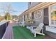 Inviting front porch with a custom welcome sign, artificial grass, white Adirondack chairs, and decorative accents at 5065 Sunrise Ln, Cumming, GA 30041