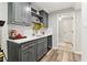 A stylish wet bar featuring gray cabinets, white countertops, and modern fixtures at 5065 Sunrise Ln, Cumming, GA 30041
