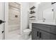 Stylish bathroom with marble tile, modern fixtures, and floating shelves at 57 Moury Se Ave, Atlanta, GA 30315
