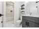 Modern bathroom with a sleek vanity, updated fixtures, floating shelves, and a shower and tub combination at 57 Moury Se Ave, Atlanta, GA 30315