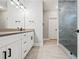 Modern bathroom with double vanity, tiled floor, and frameless glass shower enclosure at 57 Moury Se Ave, Atlanta, GA 30315