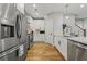 Contemporary kitchen with stainless steel appliances, white cabinets, quartz countertops, and hardwood floors at 57 Moury Se Ave, Atlanta, GA 30315