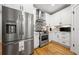 Modern kitchen with stainless steel appliances, white cabinets, tile backsplash, and hardwood floors at 57 Moury Se Ave, Atlanta, GA 30315