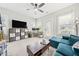 Cozy living room features a ceiling fan, natural light, a workspace, and a comfortable blue sectional at 57 Moury Se Ave, Atlanta, GA 30315