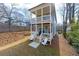 Inviting rear exterior view showcases a multi-level balcony, landscaped yard, and cozy patio seating area at 57 Moury Se Ave, Atlanta, GA 30315