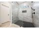Contemporary walk-in shower features gray tile, a shower niche, and black herringbone floor at 57 Moury Se Ave, Atlanta, GA 30315